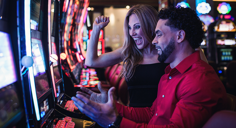 A couple playing the slots