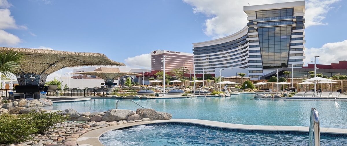 OASIS Swimming pool with canopies, trees, rocks and two casinos beside it