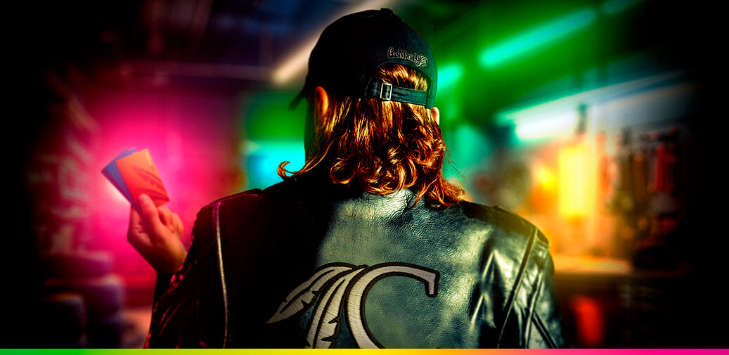 A man wearing a leather jacket holding a rewards club card