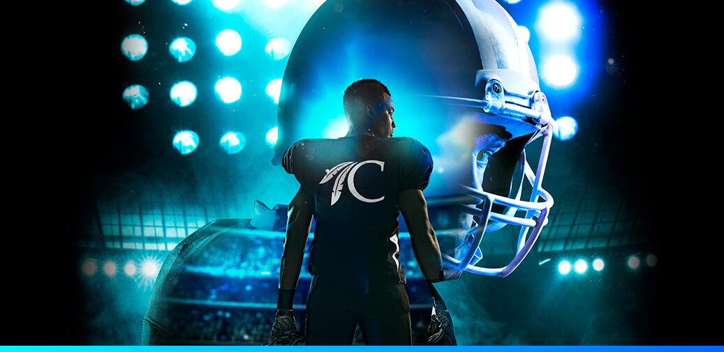 Football player standing in front of stadium lights