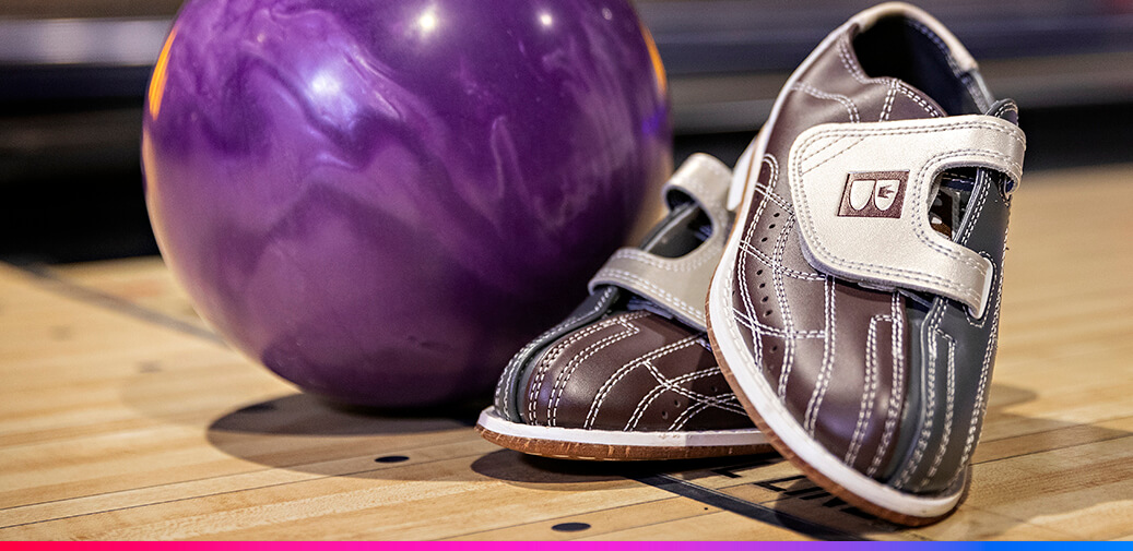 Bowling ball next to a pair of bowling shoes