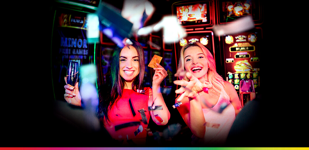 Two women celebrating in a casino with confetti.