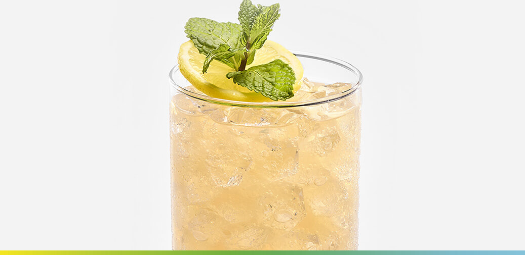 Image of a light-colored cocktail with a lemon slice and mint on top